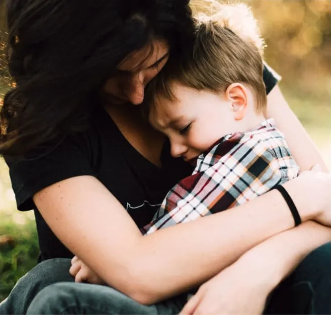 A heartfelt embrace between a mother and son amidst the beautiful fall foliage, symbolizing warmth and affection